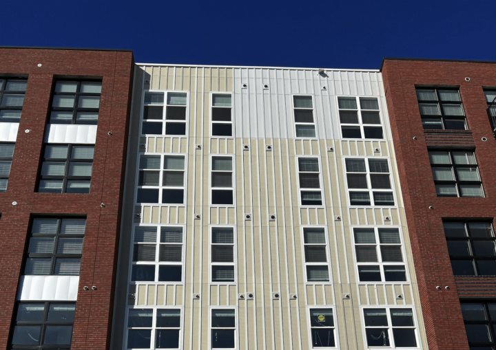 The outside of a commercial building with bricks and white siding