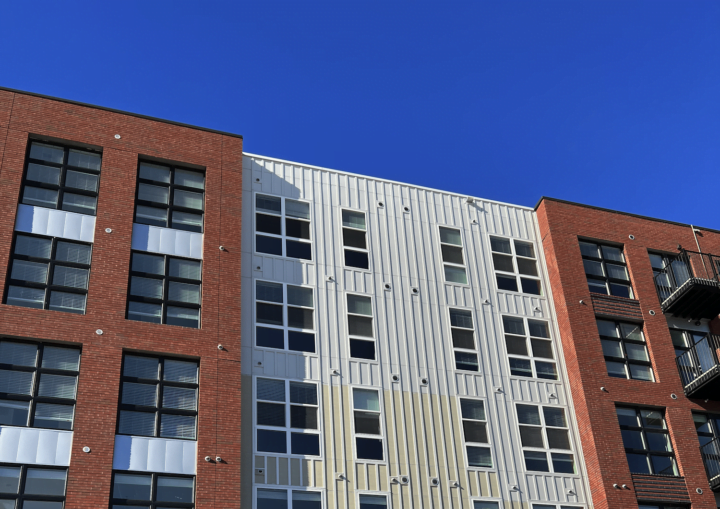 The outside of a commercial building with bricks and white siding