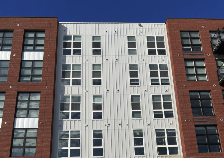 The outside of a commercial building with bricks and white siding