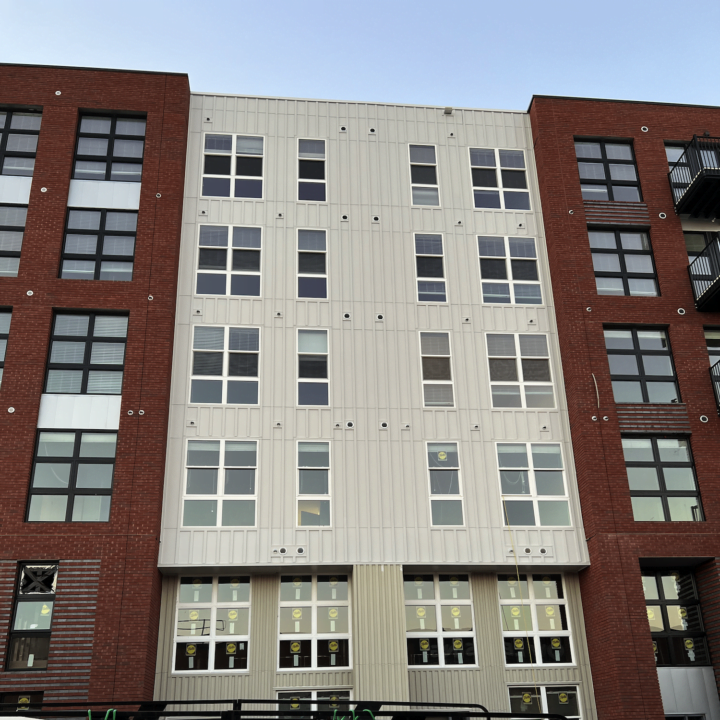 The outside of a commercial building with bricks and white siding