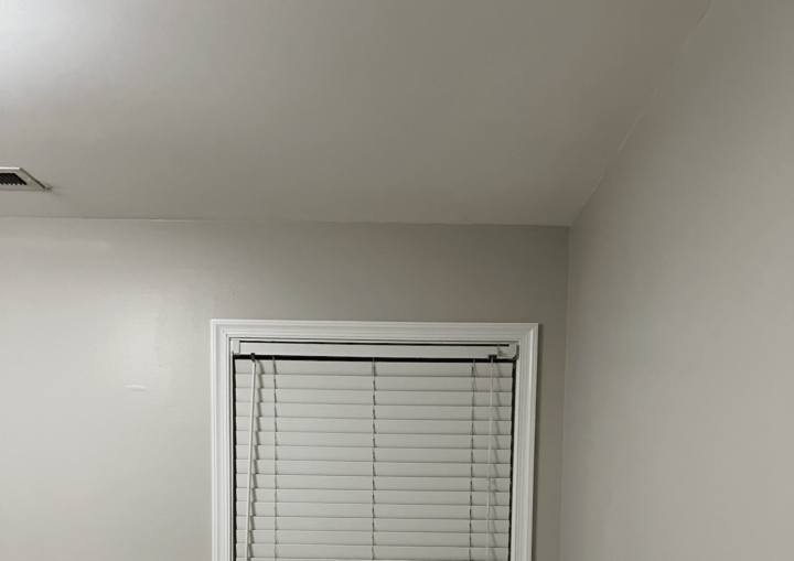 A bedroom with grey walls and white trim