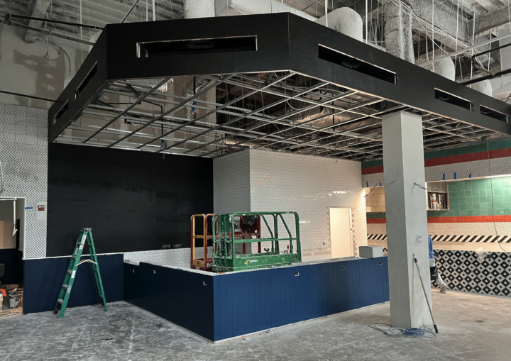 The inside of a commercial space is painted with black, blue, green, and red accent paint