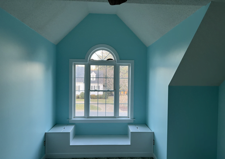 A room with a large window painted robin's egg blue