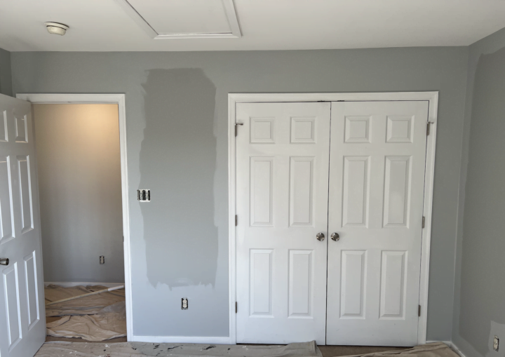 A bedroom being painted grey with white double doors