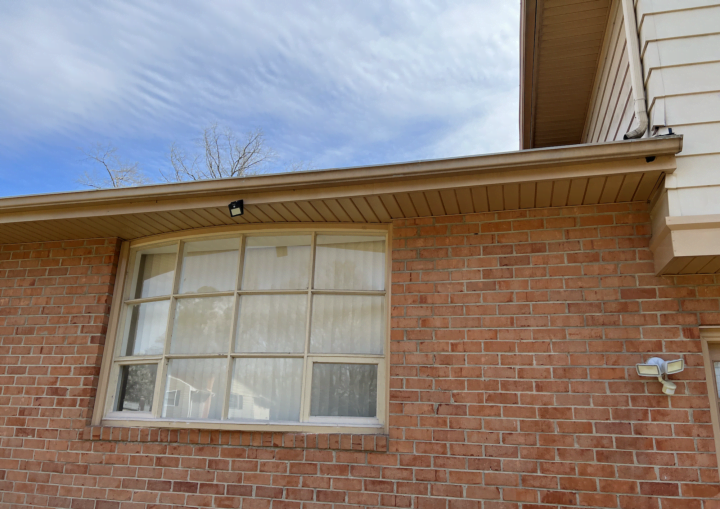 The outside of a house with siding and bricks against a blue sky