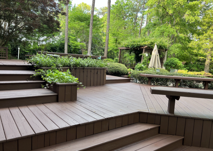 A freshly painted wooden deck, stairs, and bench in matching brown color