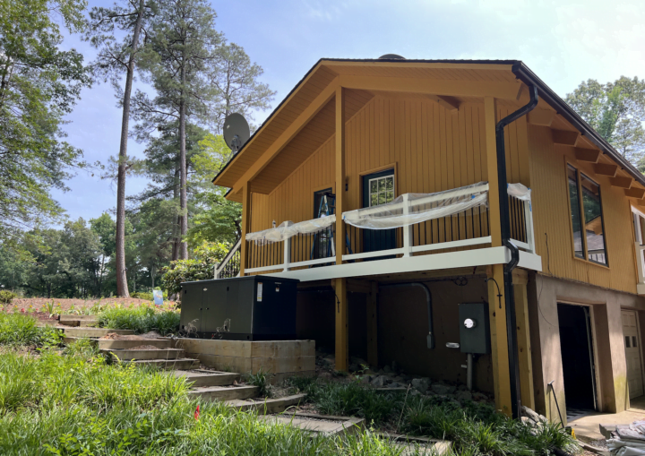 The outside of a freshly painted, modern house in a goldenrod color