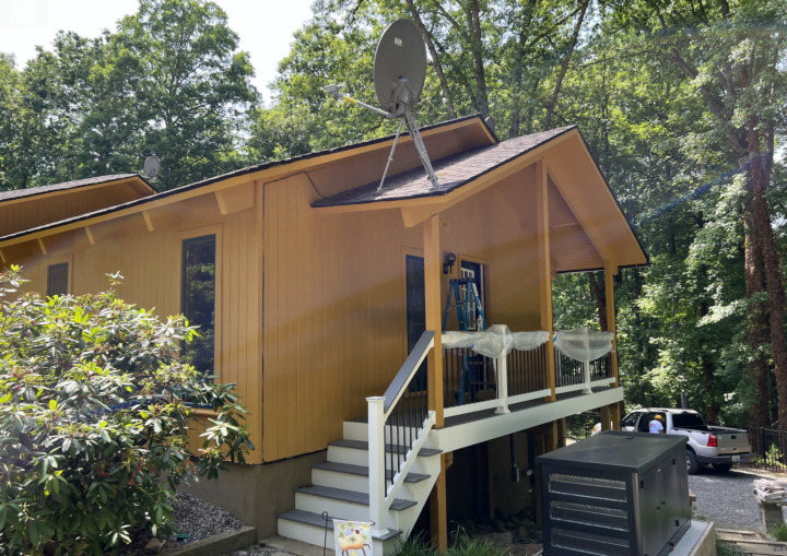 The outside of a freshly painted, modern house in a goldenrod color