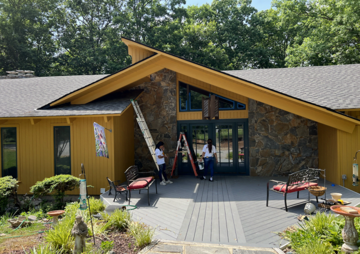 The outside of a freshly painted, modern house in a goldenrod color
