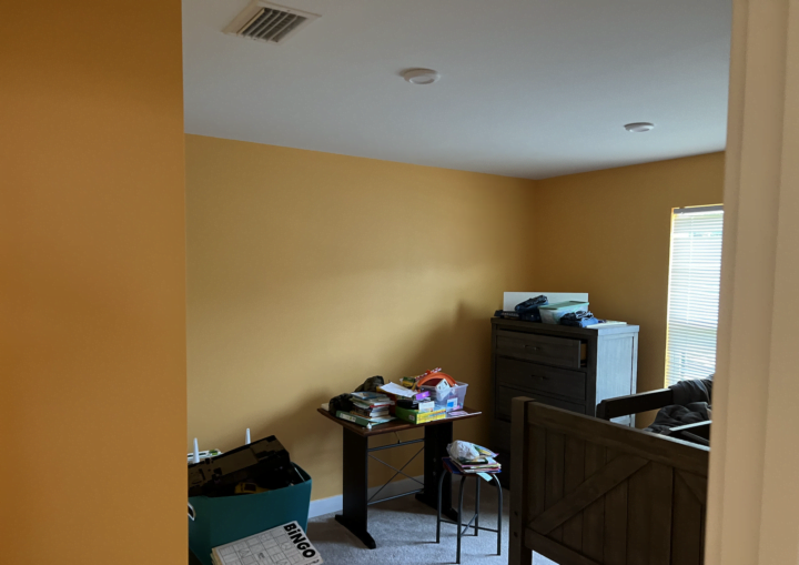 A room painted yellow with white baseboards