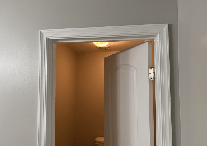 A bathroom with white trim and grey walls