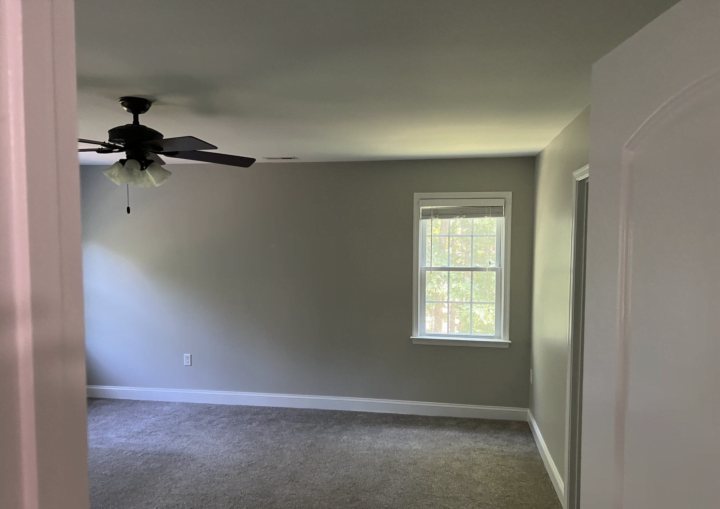 A room with grey walls and white doors and trim with grey carpet