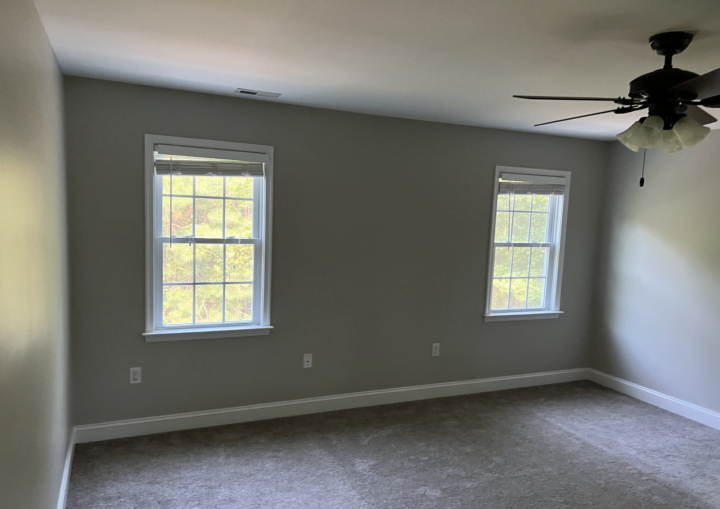 A room with grey walls and white doors and trim with grey carpet