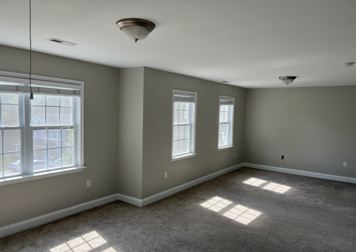 A room with grey walls and white doors and trim with grey carpet