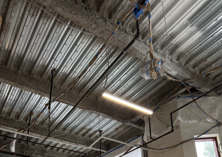 An industrial space with a metal ceiling covered with dust before painting