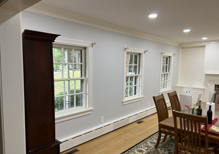 A dining room with a light blue wall and white accent trim