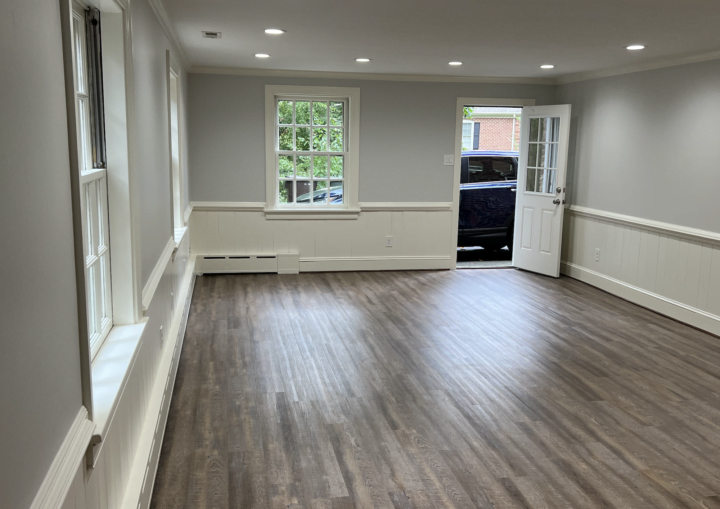 A living room with grey walls and white wainscoting and white trim