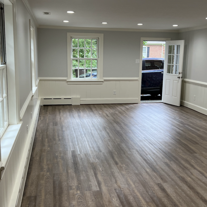 A living room with grey walls and white wainscoting and white trim